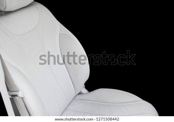 White leather interior of the luxury modern\
car. Perforated Leather comfortable white seats with stitching\
isolated on black background. Modern car interior details. Car\
detailing