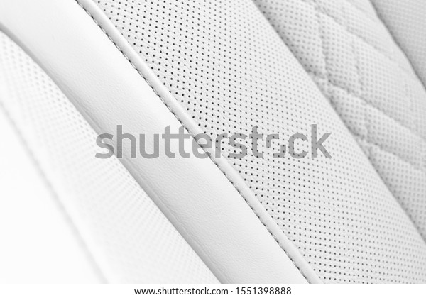 White leather interior of the\
luxury modern car. Perforated white leather comfortable seats with\
stitching. Modern car interior details. Car detailing. Car\
inside