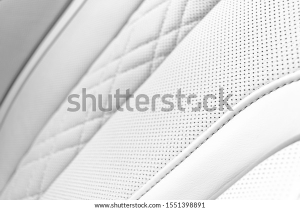 White leather interior of the\
luxury modern car. Perforated white leather comfortable seats with\
stitching. Modern car interior details. Car detailing. Car\
inside