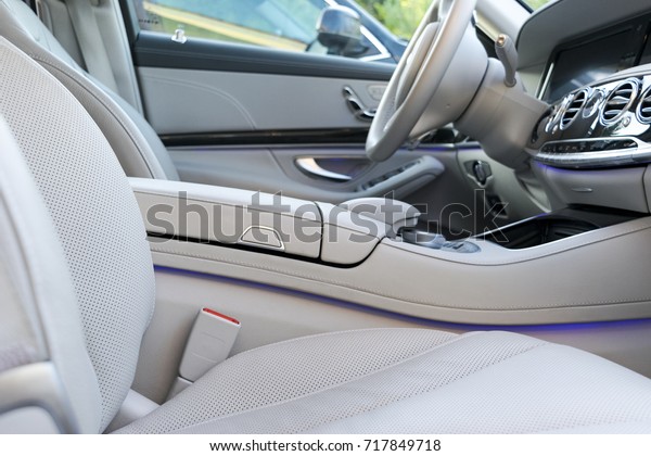 White leather interior\
of the luxury modern car. Leather comfortable white seats and\
multimedia. Steering wheel and dashboard. Automatic gear shift. Car\
interior details