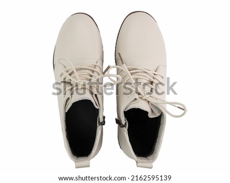 White leather sneakers. Casual women's style. White lacing and white rubber soles. Isolated close-up on white background. Top view. Fashion shoes.