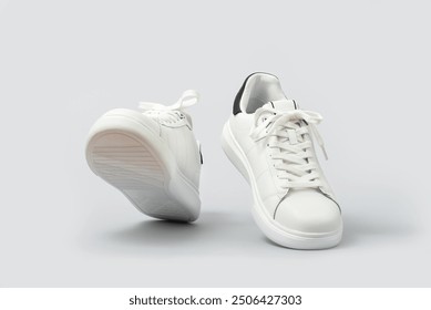 White leather sneakers isolated on gray background. Fashionable stylish sports casual shoes. Clipping path included - Powered by Shutterstock