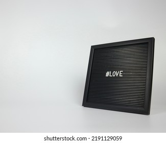 White Letters On Black Letter Board Saying Love Isolated Over White Background 