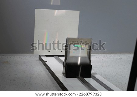 A white light beam passes through a diffraction grating slide and forms a spectrum of colors on a screen. The number of lines per millimetre is 300 and is indicated on the lattice. Physics experiment.