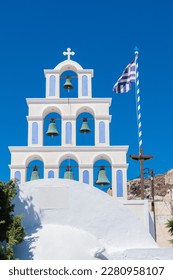 White and light blue bell tower of a church in santorini with greece flag