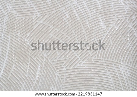 White and light brown back side of the tile with pattern of curve for background and textured.