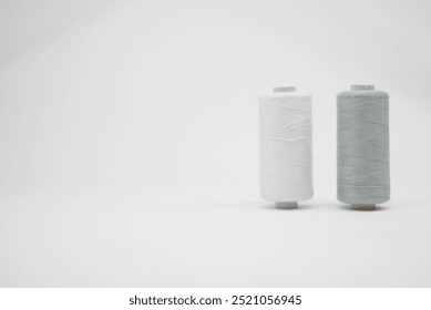 White and light grey or silver thread spools on a white background - Powered by Shutterstock