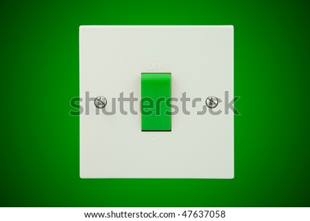 white light socket with a green switch on a green wall