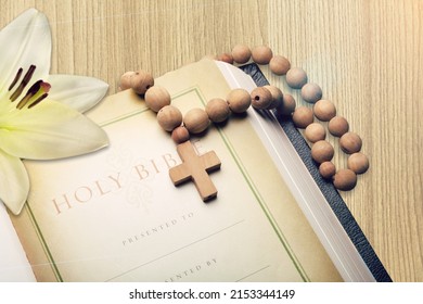 White lily, cross and holly bible book on the desk