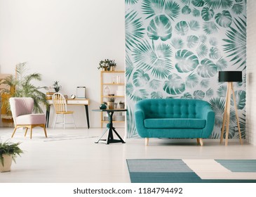 White Living Room Interior With Leafy Wallpaper In The Real Photo With Turquoise Sofa, Fresh Plants, Wooden Desk And Empty Wall With Place For Your Poster