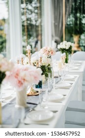 White Long Set Wedding Dinner Table With Decoration, Candlestick, Glasses, And Flowers. Selective Focus.