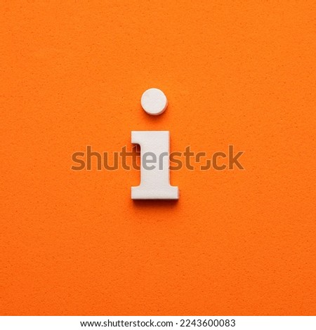 White lowercase letter i on orange foamy background