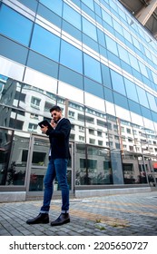 White Male Businessman Looking On His Tablet  While Talking On The Phone