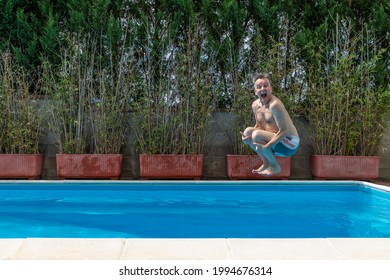 White Man With A Funny Expression Takes A Cannon Ball Dive In A Swimming Pool On A Sunny Day