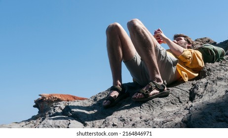 White Man Looking Phone Laying Down On A Rock