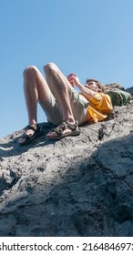 White Man Looking Phone Laying Down On A Rock