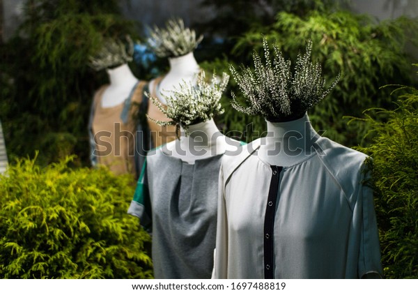 White mannequins , with heather on a dark\
green forest background. The concept of fashion, style, beauty,\
ecology, recycle, sustainability, reusing, concept. Zero and fabric\
waste, creative\
background