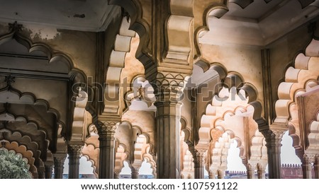 White marble arches and columns at Islamic palaces in India. Patterns and wall decorations from Mughal architecture inside Agra Fort fortress in Agra, India.