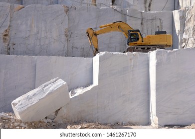 White Marble Block And An Excavator In Marble Quarry. Stone Industry