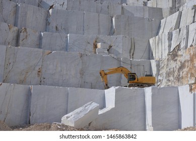 White Marble Block And An Excavator In A Marble Quarry.  Stone Industry.
