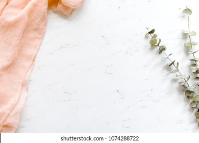 White Marble Flat Lay With Blush Textiles And Eucalyptus.