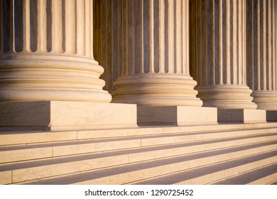 White marble neoclassical columns of the portico of the Supreme Court of the United States building in soft sunset light in Washington DC, USA - Powered by Shutterstock