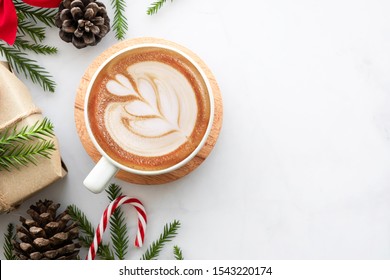 White marble table with cup of latte coffee and Christmas decoration with gift box. Christmas and new year celebration concept. Top view with copy space, flat lay. - Powered by Shutterstock