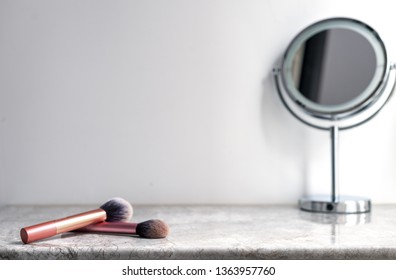 White Marble Table Top Can Used For Display Or Montage Your Products. Selective Focus Blurred White Background. Vanity Table With Makeup Brushes And  Mirror. 