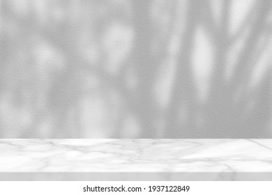 White Marble Table with Tree Branches Shadow on Concrete Wall Texture Background, Suitable for Product Presentation Backdrop, Display, and Mock up.
