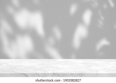 Weißer Marmortisch mit Baumblättern im Garten auf türkisem Hintergrund, geeignet für Produktpräsentationshintergrund, Anzeige und Aufziehen.