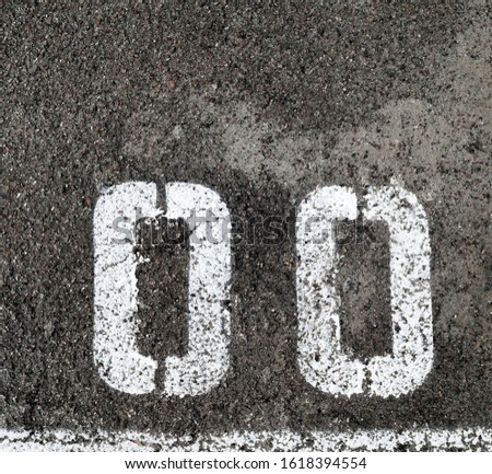 White marking lines and numbers on the asphalt surface. 