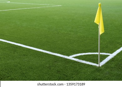 White Markings On Green Grass And Yellow Flag. Corner Of A Football Field. No People And Players. Sports Concept.