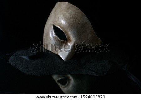 White mask on the mirror with black sand