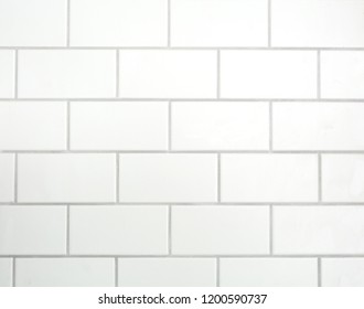 White mat tiles on a wall with grey cement