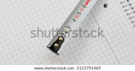 a white measuring tape on a piece of paper 