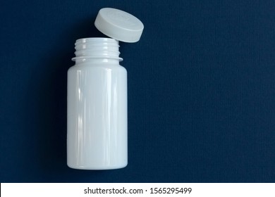 A White Medicine Bottle Stands On A Blue Background