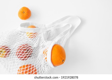 White mesh bag with fruits flat lay on white background top view. Eco friendly, reusable shopping bag. Oranges, apples, garnet in cotton knitted bag. - Powered by Shutterstock