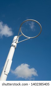 White metal netball ring from a low angle, against a blue sky