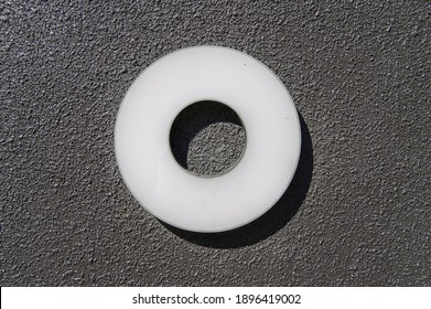 white methacrylate circle with empty center, isolated on black rough background