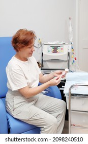 White Middle Age Woman Patient With Kidney Failure Preparing For Home Hematological Dialysis, Using Wipes To Sterilize Her Arm 