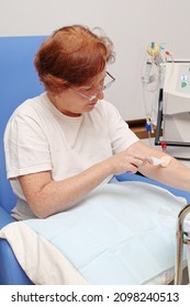 White Middle Age Woman Patient With Kidney Failure Preparing For Home Hematological Dialysis, Using Wipes To Sterilize Her Arm 