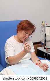 White Middle Age Woman Patient With Kidney Failure Preparing For Home Hematological Dialysis, Inserting A Needle In Her Arm