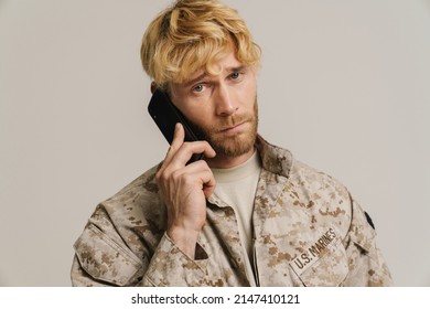 White Military Man Wearing Uniform Talking On Mobile Phone Isolated Over White Wall