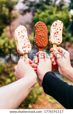White and milk chocolate ice cream in hands of three girls best friends.