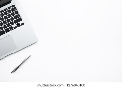 White minimalistic office desk table with laptop computer and pen. Top view with copy space, flat lay.