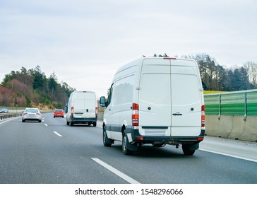 White Minivans On Road. Mini Van Auto Vehicle On Driveway. European Van Transport Logistics Transportation. Auto With Driver On Highway.