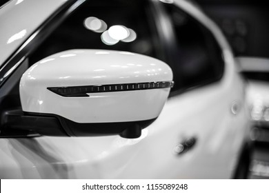 white mirror of compact SUV with turn signal, detail of car close-up