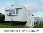 White Mobile Home With Deck and Steps in a Holiday Park