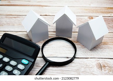 White Model House With Magnifying Glass And Calculator On Wooden Background, Realestate Concept