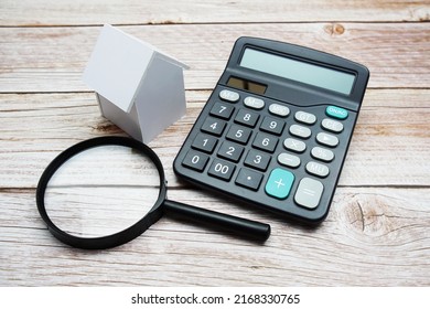 White Model House With Magnifying Glass And Calculator On Wooden Background, Realestate Concept